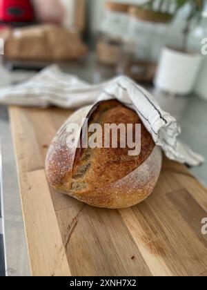 Frisch gebackenes Brot auf einem hölzernen Schneidebrett, perfekt zum Backen, Kochen und hausgemachten Speisen. Stockfoto