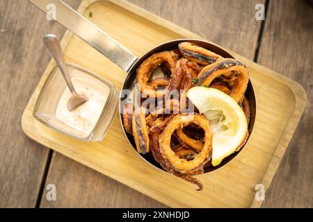 Gebratene Calamari serviert mit Zitronen- und Tatarsauce Stockfoto