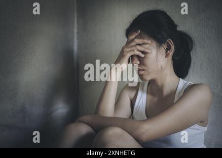 Junge Frau mit Depressionen und Angstzuständen, die auf dem Boden sitzt. Die Frau fühlt sich frustriert und verwirrt, unglücklich, persönliche Probleme, Stress. Stockfoto