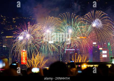 2023 Chinesisches Neujahrsfeuerwerk im Victoria Harbour, vom Hung Hom Ferry Pier mit Blick auf die Wolkenkratzer in Hong Kong Central, mit DE Stockfoto