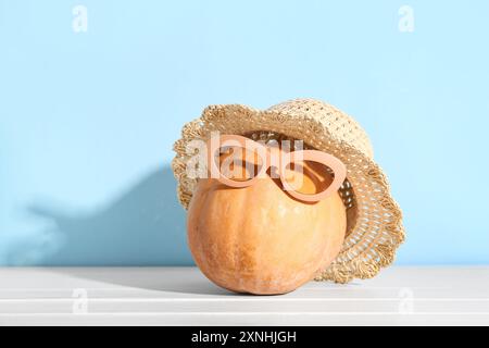 Halloween Kürbis mit Strandaccessoires auf hellem Holztisch Stockfoto