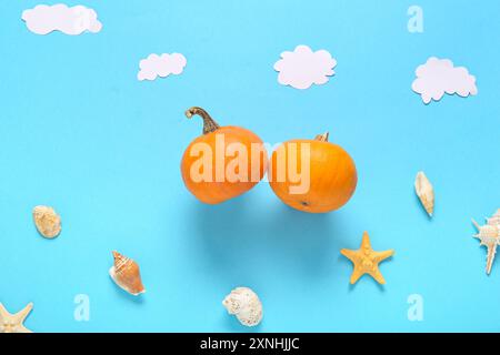 Komposition mit Halloween Kürbissen und Muscheln auf blauem Hintergrund Stockfoto