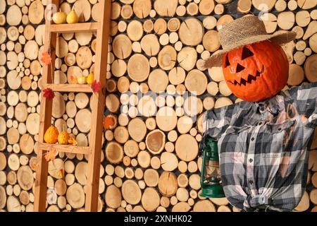 Vogelscheuche mit Halloween-Kürbis in der Nähe einer Holzwand im Zimmer Stockfoto