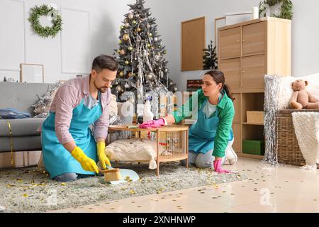 Junge Hausmeister putzen im Zimmer nach Neujahrsfeier Stockfoto