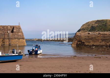 Boote bei Ebbe im Cove Harbour (Hafen) an der Ostküste Schottlands, Vereinigtes Königreich, Stockfoto