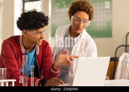 In der Highschool, Teenager, die Laptop benutzen und im Labor über Wissenschaftsprojekte diskutieren Stockfoto