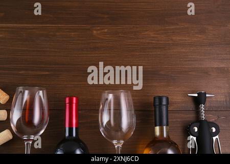 Flache Lagenkomposition mit Flügelkorkenzieher und Wein auf Holztisch. Leerzeichen für Text Stockfoto