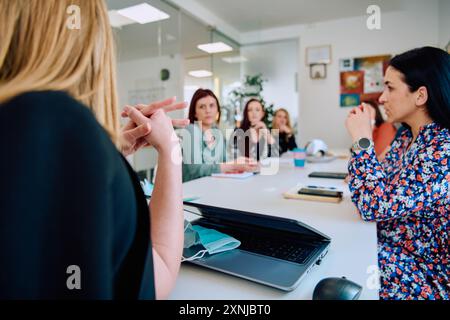 Diverse Geschäftsteams diskutieren Projekte in einem modernen Glasbüro. Stockfoto