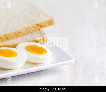 Gekochtes Ei und Toast auf weißem Teller Stockfoto