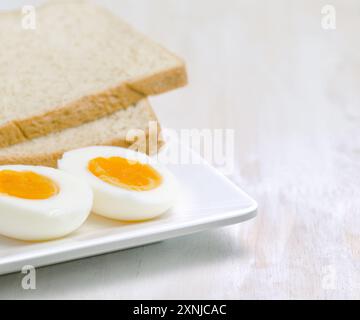 Gekochtes Ei und Toast auf weißem Teller Stockfoto