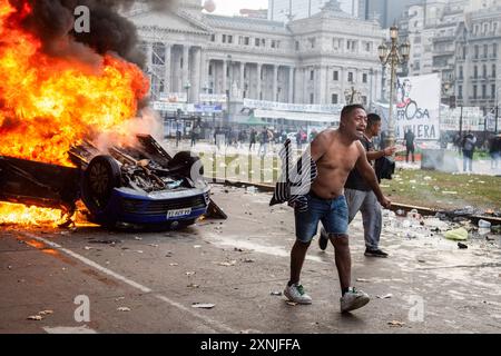 Buenos Aires, Argentinien. Juni 2024. Demonstranten, die während der Repression vor dem Nationalkongress in der Nähe eines brennenden Fahrzeugs gesehen wurden, am Tag der Behandlung des von der Regierung geförderten Basen-Gesetzes. Der Senat der Nation genehmigte das Gesetz der Basen und Ausgangspunkte für die Freiheit der Argentinien, während außerhalb des Gebäudes eine heftige Repression gegen die Demonstranten durchgeführt wurde, die kamen, um die besagte Behandlung des Gesetzes abzulehnen. (Credit Image: © Nehuen Rovediello/SOPA Images via ZUMA Press Wire) NUR REDAKTIONELLE VERWENDUNG! Nicht für kommerzielle ZWECKE! Stockfoto