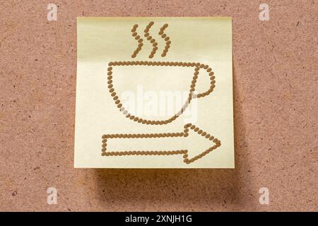 Heiße Tasse Kaffee und Pfeil gezeichnet mit Kaffeebohnen auf Memorynotiz, die an Bord geklebt ist Stockfoto