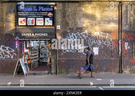 Eine Frau spaziert entlang der Rye Lane in Peckham Rye, South London. Stockfoto