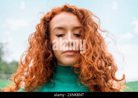 Nahaufnahme des Porträts einer rothaarigen, unglücklichen jungen Frau mit lockigem rotem Haar, die E-Mails auf dem Laptop liest und frustriert über schlechte Nachrichten ist Stockfoto
