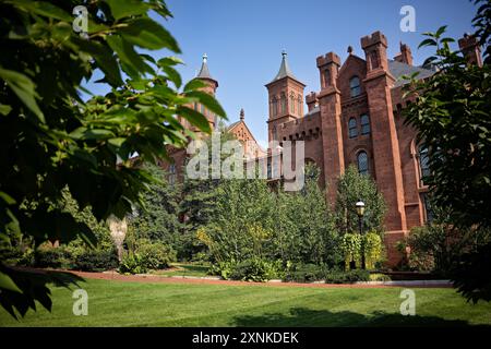 Smithsonian Castle Enid A Haupt Garden Washington DC // WASHINGTON DC — das Smithsonian Castle wird durch den Enid A. Haupt Garden auf der National Mall in Washington, D.C. besichtigt. Das rote Sandsteinschloss wurde 1855 fertiggestellt und dient als Hauptsitz und Besucherzentrum der Smithsonian Institution. Der 4 Hektar große Hauptgarten mit formellen Bepflanzungen und Springbrunnen wurde 1987 als Teil des Quadrangle-Komplexes eröffnet. Stockfoto
