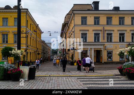 Blick auf eine der Hauptstraßen des alten Helsinki, die Lage von Sofia, einem luftigen und modernen Kaufhaus mit Flaggen auf der schmalen Straße Helsin Stockfoto