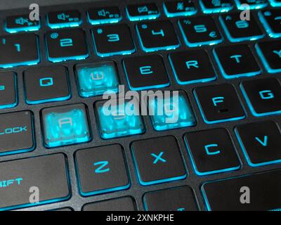 Eine Nahaufnahme einer blauen hintergrundbeleuchteten RGB-Tastatur auf einem Gaming-Notebook. Bild mit selektivem Fokus Stockfoto