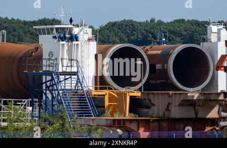 31. Juli 2024, Mecklenburg-Vorpommern, Stralsund: Der Schwerlastponton „BHV Innovation“ wird mit runden Stahlpfählen beladen. Die Monopiles für Windturbinen sollen in der Volkswerft Korrosionsschutz erhalten. Monopiles werden beim Bau von Offshore-Windturbinen eingesetzt. Foto: Stefan sauer/dpa/ZB Stockfoto