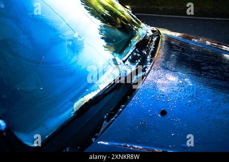 Ein Foto, das das geschmolzene Eis auf der Oberfläche eines SUV-Autos am frühen Morgen aufnimmt und das Frostmuster und den Auftaueffekt zeigt. Stockfoto