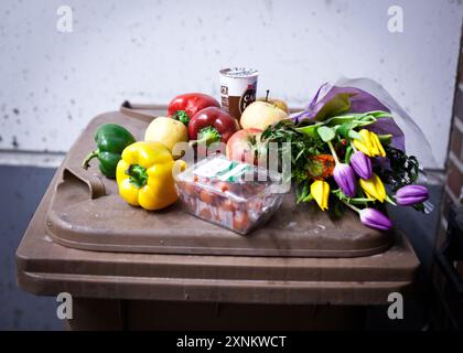 Eine Sammlung von Gemüse, Früchten und Blumen, die beim Tauchen in Müllcontainern gesammelt wurden. Dieses Bild zeigt Lebensmittelverschwendung und den potenziellen Wert von weggeworfenen Supermarktartikeln und symbolisiert die Notwendigkeit der Nachhaltigkeit. Stockfoto