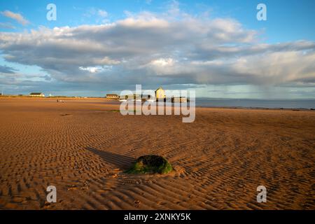 Elie Hafen und Kornspeicher leuchten durch das goldene Sonnenuntergangslicht über den Gezeiten des Sandes Elie Fife Scotland Stockfoto