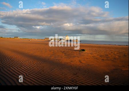 Elie Hafen und Kornspeicher leuchten durch das goldene Sonnenuntergangslicht über den Gezeiten des Sandes Elie Fife Scotland Stockfoto