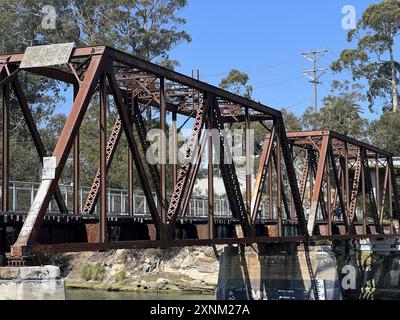 Rustikale San Lorenzo River Railroad Bridge aus Metall überspannt einen Fluss mit üppigen Bäumen im Hintergrund an einem sonnigen Tag, Santa Cruz Beach Boardwalk, Santa Cruz, Kalifornien, 22. Juni 2024. (Foto: Smith Collection/Gado/SIPA USA) Stockfoto