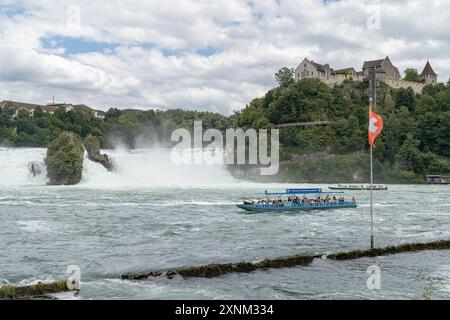 Schaffhausen, Schweiz - 17. Juli 2024: Touristenboot fährt in der Nähe des Rheinfalls, des größten Wasserfalls Europas Stockfoto