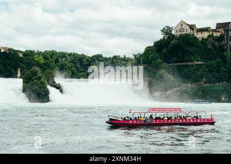 Schaffhausen, Schweiz - 17. Juli 2024: Touristenboot fährt in der Nähe des Rheinfalls, des größten Wasserfalls Europas Stockfoto