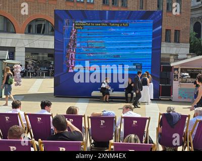 London, Vereinigtes Königreich. August 2024. UK Weather – Büromitarbeiter genießen ihre Mittagspause am Paternoster Square, während sie die Olympischen Spiele auf einer Großleinwand beobachten. Quelle: Uwe Deffner/Alamy Live News Stockfoto