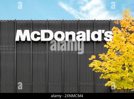 McDonalds Restaurant Logo auf Metallwand mit gelbem Ahornbaum im Herbst Stockfoto