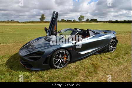 Schwarzer McLaren 720er-Wagen mit offener Tür auf dem Feld. Stockfoto