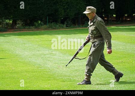 Mann, der in deutscher Uniform des Zweiten Weltkriegs mit Gewehr läuft. Stockfoto