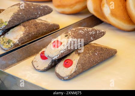 Hausgemachtes süßes Gebäck Cannolo siciiano gefüllt mit Mandel, Pistazien, Zitronen, Vanille und Schokoladencreme auf dem Lebensmittelmarkt in Italien Stockfoto