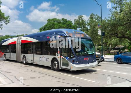 San Antonio, Texas, USA – 8. Mai 2023: Ein Gelenkbus VIA Metropolitan Transit fährt auf einer Straße in San Antonio, Texas. Stockfoto