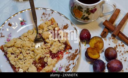 Hausgemachter Pflaumenkuchen auf einem Teller, eine Gabel, Pflaumen, Zimt. Stockfoto