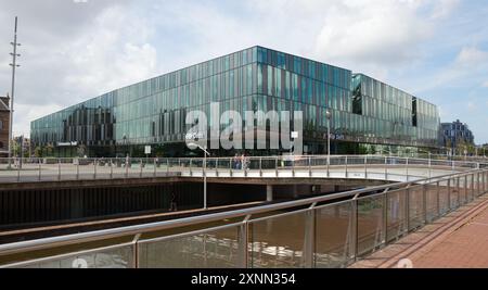 DELFT, SÜDHOLLAND, NIEDERLANDE - 26. JULI 2024: Blick auf den Bahnhofsplatz mit dem Bahnhof Delft und dem Rathaus. Stockfoto