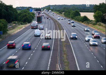 Die Autobahn M40 zwischen den Anschlussstellen 9 und 10 in der Nähe von Bicester und Oxford zeigt Autos, Lastwagen und Reisebusse, die an einem Sommerabend in Oxfordshire fahren Stockfoto