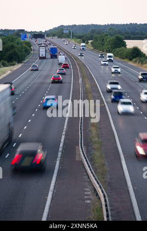 Die Autobahn M40 zwischen den Anschlussstellen 9 und 10 in der Nähe von Bicester und Oxford zeigt Autos, Lastwagen und Reisebusse, die an einem Sommerabend in Oxfordshire fahren Stockfoto