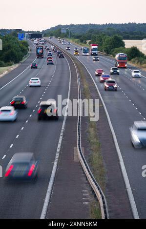 Die Autobahn M40 zwischen den Anschlussstellen 9 und 10 in der Nähe von Bicester und Oxford zeigt Autos, Lastwagen und Reisebusse, die an einem Sommerabend in Oxfordshire fahren Stockfoto