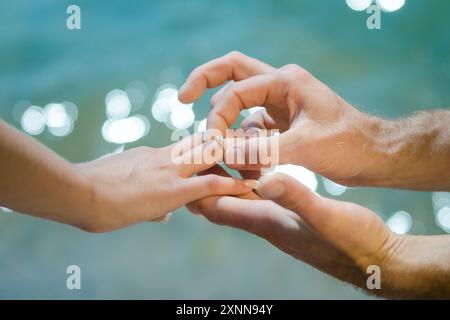 Guys Hand legt einem Mädchen einen Ehering auf die Hand Stockfoto