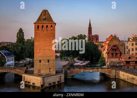 Ponts Couverts bedeckten Brücken und ihre Türme auf den Kanälen im Stadtteil Petite France in Straßburg, Elsass, Frankreich bei Sonnenuntergang Stockfoto