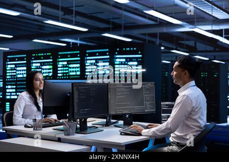 Team von Technikern im Rechenzentrum, die die Leistung der Geräte auf dem Computer nach der Aktualisierung der Infrastruktur überprüfen. Teamwork-IT-Mitarbeiter, die die Wartung von Speicher-Arrays im Serverraum durchführen Stockfoto