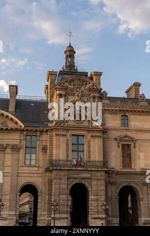 Paris, Frankreich - 29. Juli 2024: Kunstvoller Eingang des Louvre-Palastes bei Sonnenuntergang Stockfoto