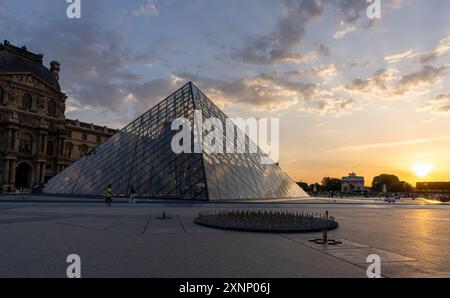 Paris, Frankreich - 29. Juli 2024: Sonnenuntergang über der berühmten Glaspyramide und dem historischen Louvre Stockfoto
