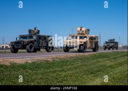 Three Humvees sind auf dem Weg zu einem Trainingsszenario der Streitkräfte auf der Minot Air Force Base, North Dakota, am 31. Juli 2024. Einsatzszenarien sind eine wertvolle Ausbildung, bei der die der 5. Sicherheitskräfte-Geschwader zugeordneten Flugzeuge zusammenarbeiten, um eine einzelne Mission zu erfüllen. (Foto der U.S. Air Force von Senior Airman Alexander Nottingham) Stockfoto