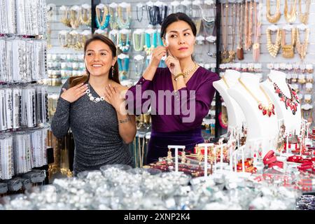 Zwei junge Frauen, die Bijouterie im Juweliergeschäft auswählen Stockfoto