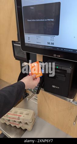 Eine Frau bezahlt mit einer Kreditkarte für ihre Sachen im Shoppers Drug Mart. Stockfoto