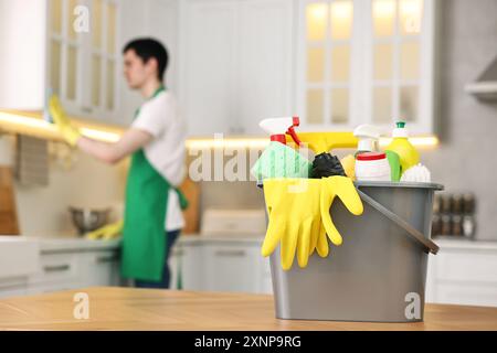 Professioneller Hausmeister, der in der Küche arbeitet, konzentriert sich auf Eimer mit Zubehör. Reinigungsservice Stockfoto