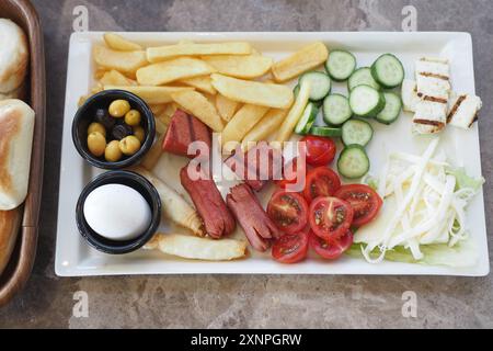 Köstliches Frühstücksgericht mit frischem Gemüse, Käse, Würstchen und gebratenem Ei Stockfoto